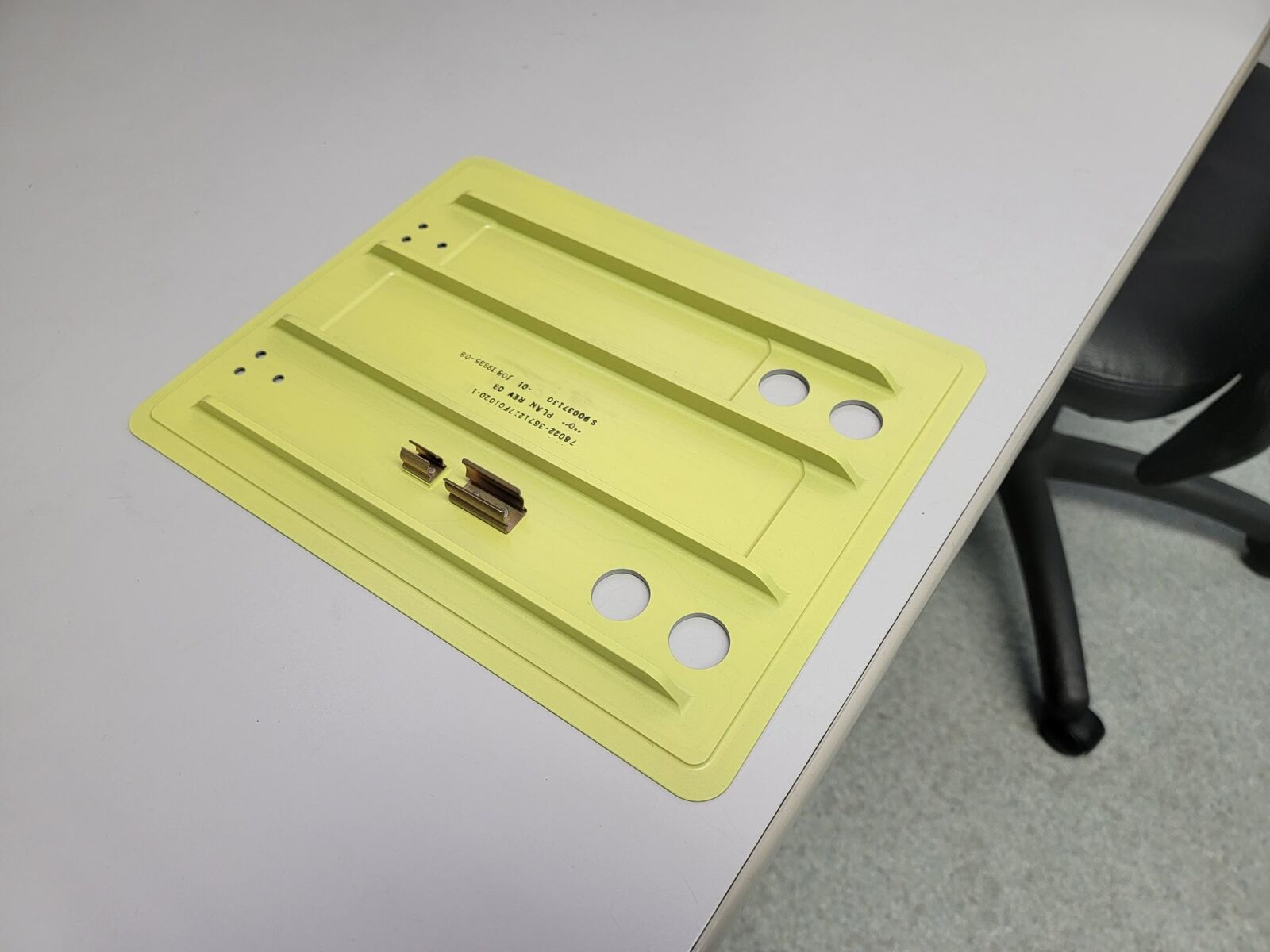 Flat plate with yellow coating, slots and holes