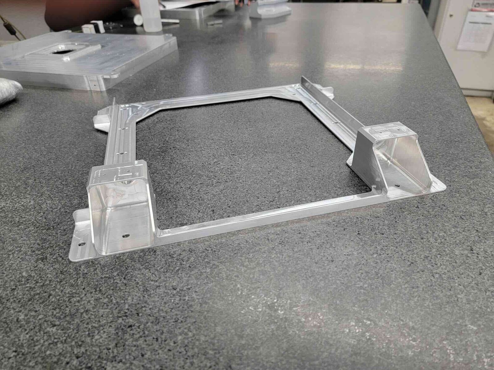 Machined aluminum frame with corner blocks on granite table