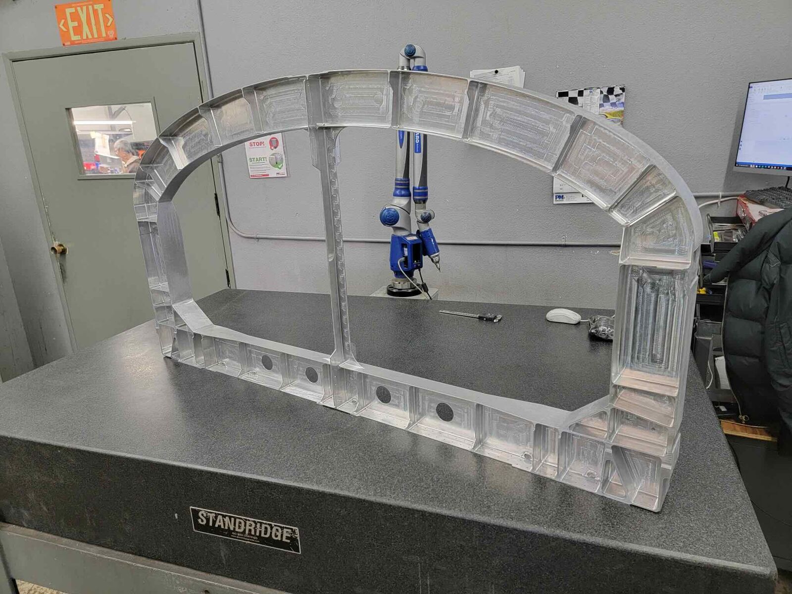 Arch-shaped machined aluminum frame on a granite inspection table