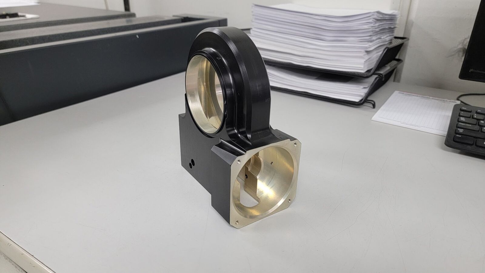 Black anodized housing with a brass bore