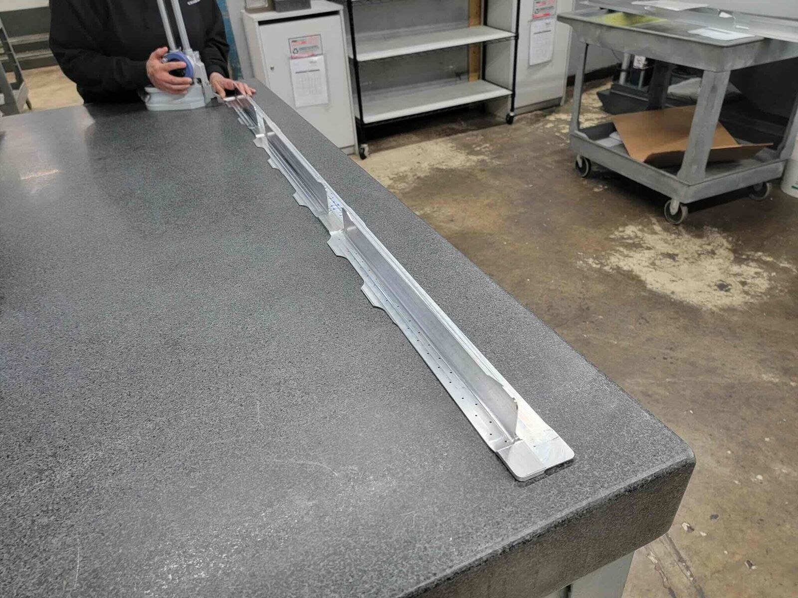 Long machined aluminum rail on granite table