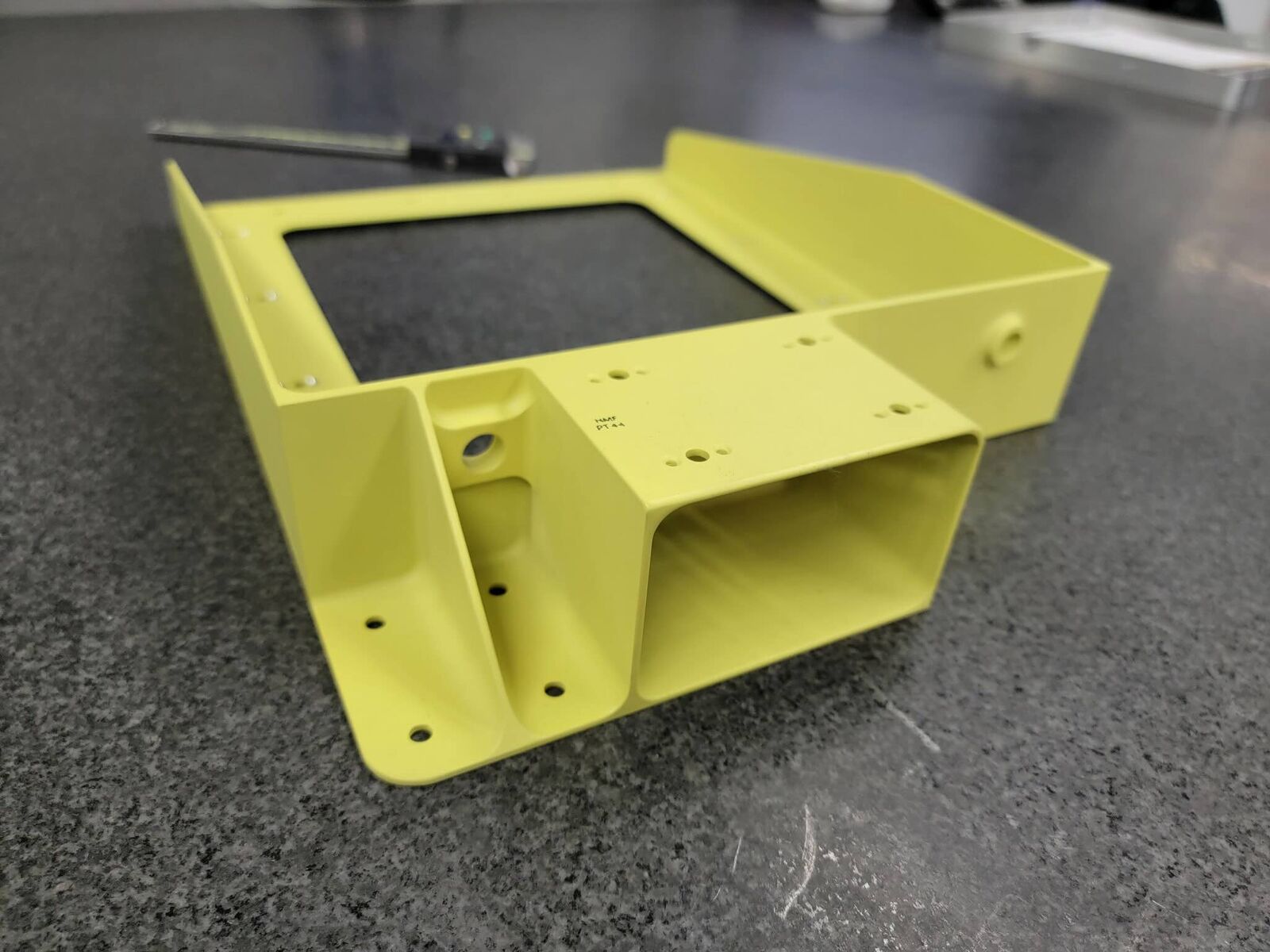 Machined box with yellow coating and square opening