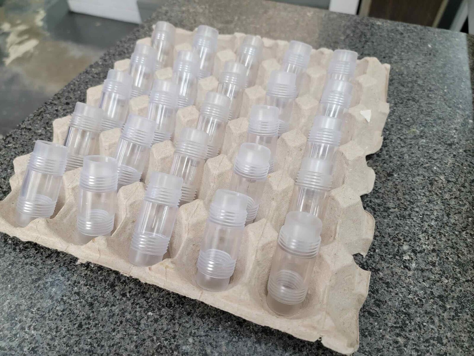 Clear plastic machined parts arranged in a tray