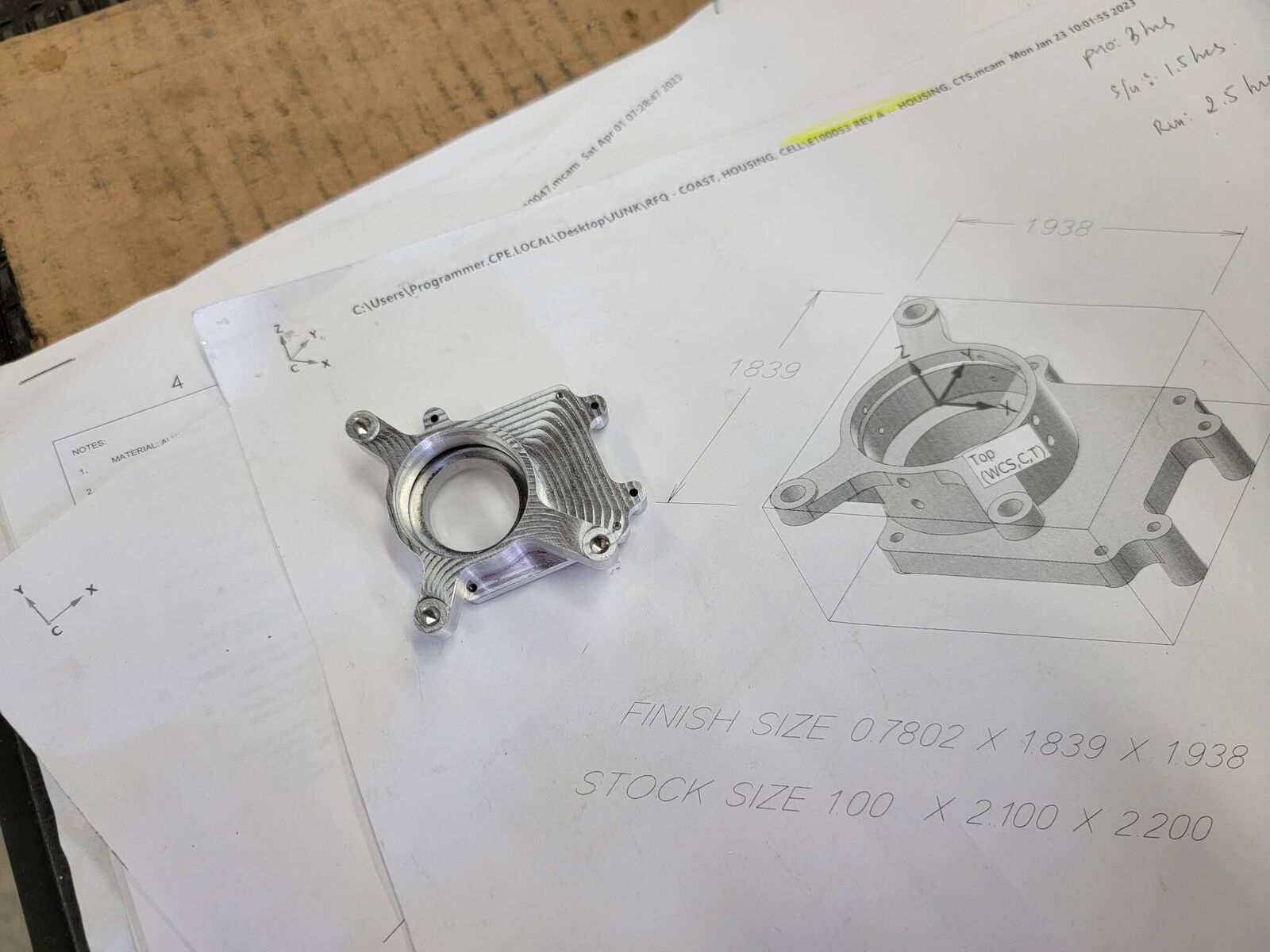 Small turned aluminum parts beside their engineering drawing
